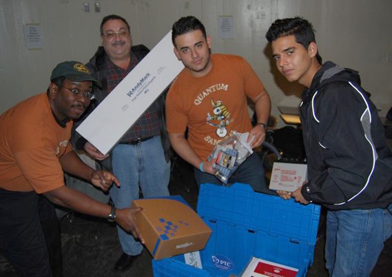 Members of the Aviation robotics team are pictured displaying the contents of the kit of parts with their mentors.