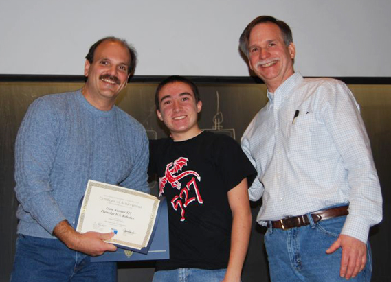 Members of the Connetquot robotics team are pictured displaying the contents of the kit of parts with their mentor.