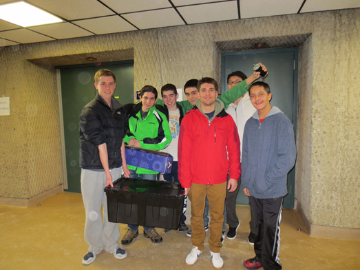 Members of the Wheatley High School robotics team pose with the contents of the kit of parts.